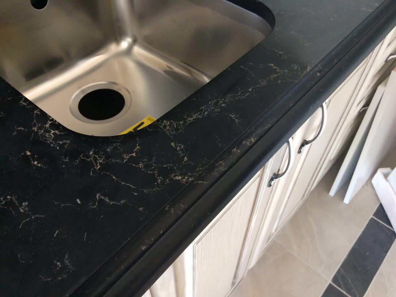 Black marble countertop with white cabinets 